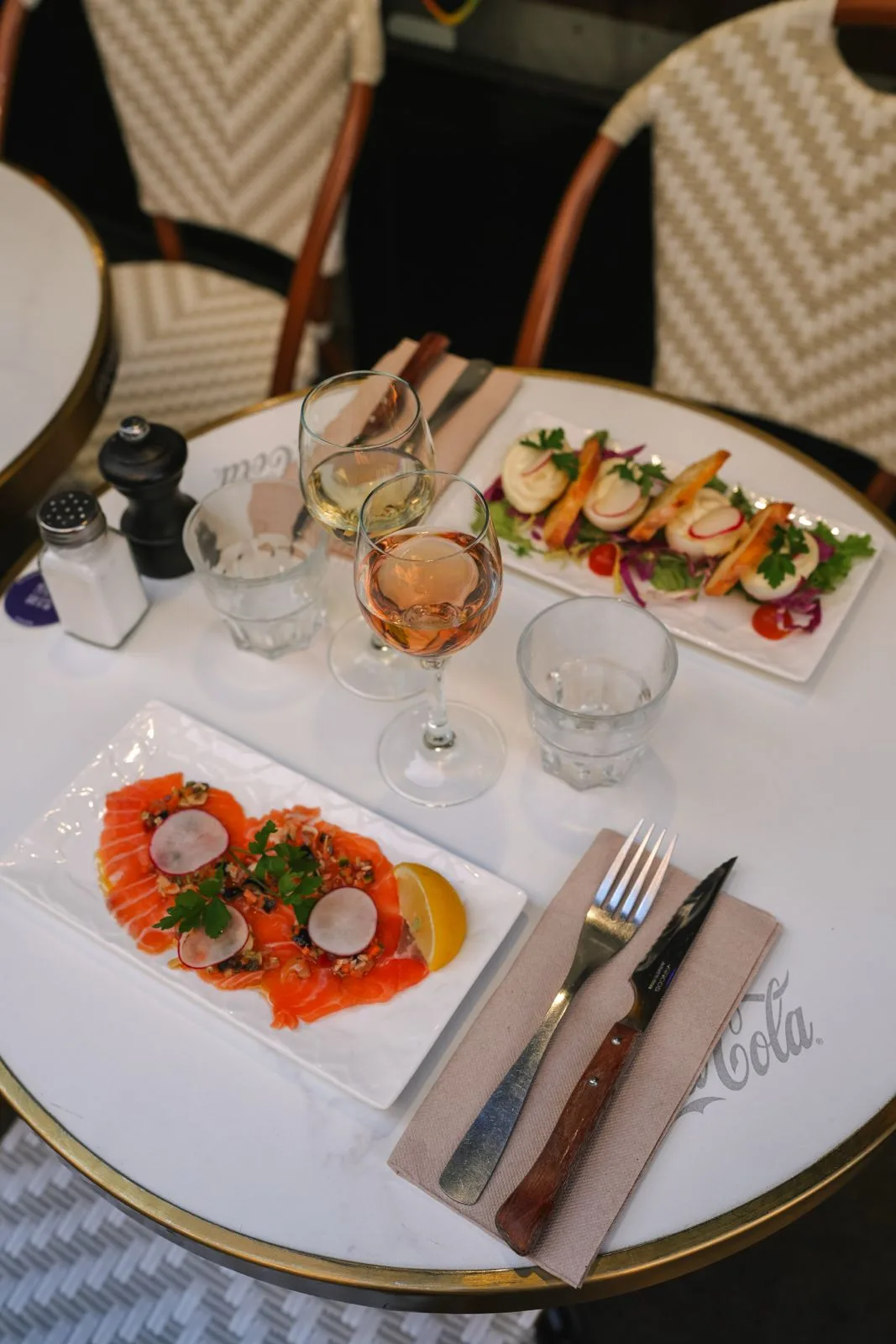 Table à deux dressée avec carpaccio et verres de vin